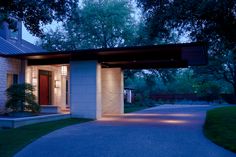 a house with a walkway leading to the front door and entrance at night, lit up by outdoor lighting