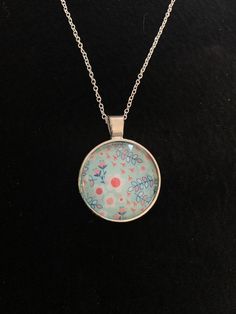 Light blue and coral floral design round silver pendent on an 18 in chain. P Round Floral Print Jewelry For Gift, Floral Print Round Jewelry For Gifts, Round Floral Print Jewelry Gift, Blue Floral Print Jewelry For Gift, Blue Metal Round Pendant Necklace, Floral Print Round Jewelry Gift, Blue Flower Pendant Necklace Nickel Free, Blue Nickel-free Round Pendant Necklace, Nickel-free Blue Round Pendant Necklace