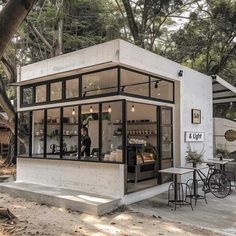 a small white building sitting on top of a sandy beach