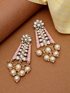 These beautiful gold-toned baby-pink & classic earrings come with kundan stone studs & pearls, are gold-plated, and are secured with a post and back closure. These danglers can be styled with any ethnic outfit for a modern twist, or easily accentuate any non-traditional outfit for an eye-catching look. Product color may vary based on the monitor or screen you are using.See FAQ for more details. Size Length: 10.5 cm Details Material: BrassStones: Kundan & PearlPlating: Gold-plated Pink Kundan Earrings For Reception, Pink Chandbali Earrings For Reception, Bollywood Style Pink Earrings For Reception, Pink Earrings For Reception And Festivals, Pink Stone Work Danglers For Celebration, Festive Pink Stone Work Danglers, Pink Bridal Earrings For Reception And Festive Occasions, Pink Bridal Earrings For Reception And Festive Season, Traditional Pink Pearl Earrings For Festive Occasions