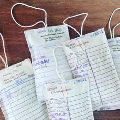 three bags with some writing on them sitting on a wooden table next to each other