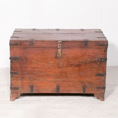 an old wooden trunk sitting on top of a white floor