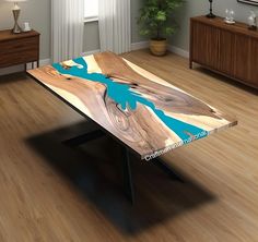 a wooden table with blue paint on it in the middle of a wood floored room