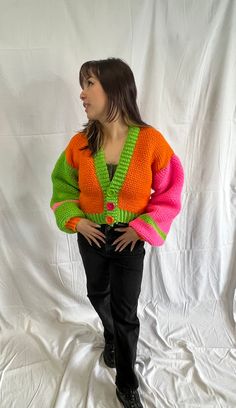 This sweater is so lush and cozy, you'll want to live in it. It's made with an acrylic blend yarn that is on the lightweight side making is perfect for all seasons, and it's buttery soft. The lightweight yarn means you can pair it with an outfit for warmer weather or layer it and stay warm in the cold. The sweater is neon pink, green and orange, and has three buttons for front closure. This sweater fits like a S/M. There is ribbing along the edges and at the wrists. Trendy Knitted Sweater For Spring, Spring Knitted Acrylic Sweater, Oversized Hand Knitted Spring Sweater, Spring Cozy Sweater In Acrylic Yarn, Cozy Acrylic Yarn Sweater For Spring, Slouchy Knitted Sweater For Spring, Hand Knitted Acrylic Sweater For Spring, Trendy Hand Knitted Sweater For Spring, Trendy Hand-knitted Sweater For Spring