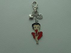 a keychain with a woman holding a red heart on it's side