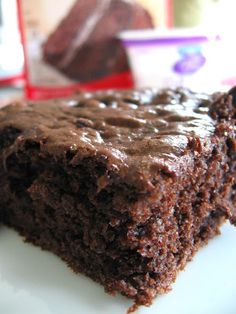 a piece of chocolate cake sitting on top of a white plate next to a package of milk