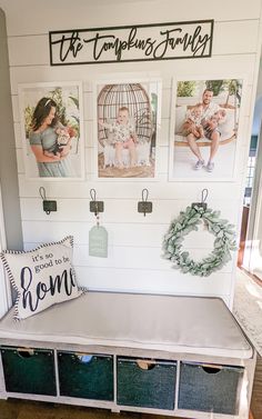 a bench that has some pictures on the wall above it and two baskets with wreaths