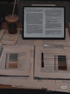 an open book sitting on top of a table next to a cup of coffee and pen