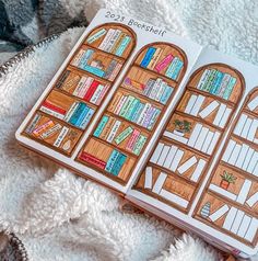 an open book with bookshelves on it sitting on top of a white blanket