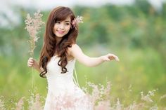 a girl in a white dress holding pink flowers with the words blossom tree branch on it