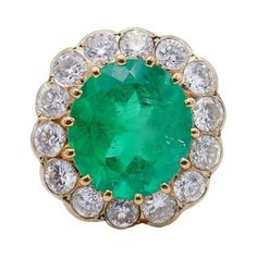 A classic cluster 18 karat yellow gold ring with a Colombian emerald and diamond. The emerald comes with a GRS Gemstone Report. This gorgeous gold ring features a faceted oval emerald surrounded by a halo of fourteen bezel set diamonds (please see details below). Colombian emeralds are considered the purest and highest quality emeralds on the planet. Cluster rings are always in fashion. This massive vintage emerald ring is a head-turner and your perfect companion for a cocktail party. This bold French vintage cocktail ring is made of 18 karat yellow gold and features an approximately 7.70-carat oval faceted emerald (13.80 x 12.14 x 8.69 mm), accented with fourteen round brilliant cut diamonds (G-H color, VS clarity, total weight 2.10 carats). This emerald ring top measures 13/16” x ¾” x 3/ Cocktail Vintage, Emerald Ring Vintage, Vintage Cocktail Ring, Colombian Emeralds, Bezel Set Diamond, Green Gems, 18k Gold Ring, Emerald Jewelry, Yellow Gold Ring