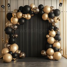 a black and gold balloon arch with lots of balloons