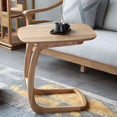 a wooden table sitting on top of a rug next to a couch