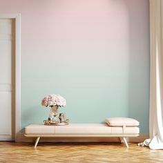 a white bench with flowers on it in front of a blue wall and wooden floor