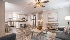 a living room filled with furniture and a ceiling fan