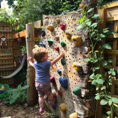 a little boy climbing up the side of a rock wall