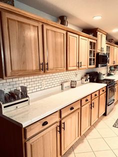 a kitchen filled with lots of wooden cabinets and white counter top space next to an oven