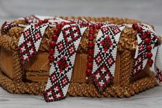 a woven basket with red, white and black beaded trimmings on it