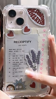 a person holding up a phone case with stickers on it