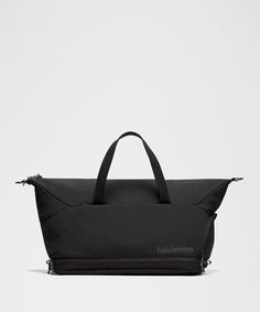 a black duffel bag sitting on top of a white surface