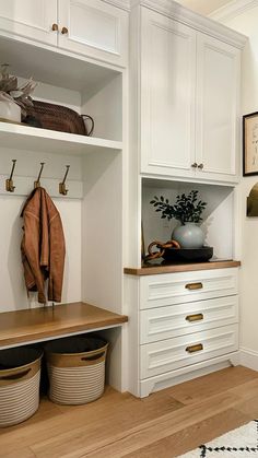 an entryway with white cabinets and baskets