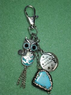 an owl keychain with two charms attached to it