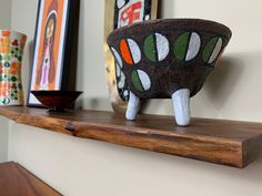 a wooden shelf with some art on it