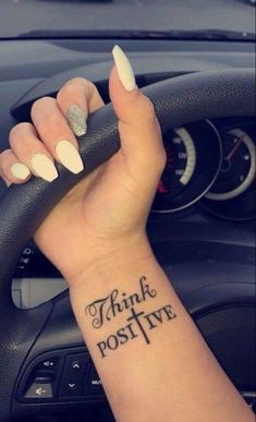 a woman's arm with a tattoo on it and the words think positive in black ink