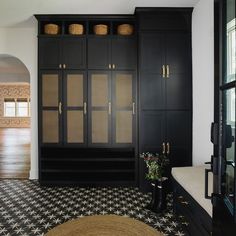 a black and white tiled floor in a living room with built - in storage cabinets