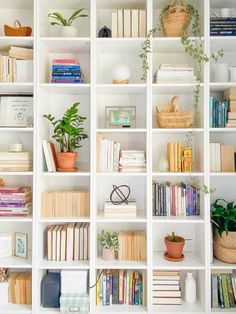 the bookshelf is filled with many different types of books and plants on it