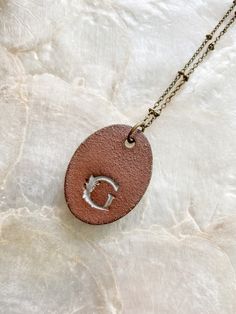 This handmade oval clay pendant is imprinted with the seeds of a Sea Oat plant (Uniola paniculata) collected from the Texas coast then finished with a rustic white glaze. Pendant measures roughly 1"x1.5" and is on a 24" antiqued brass satellite chain with lobster clasp closure. Included tag has species name and back of pendant has a small "G" logo. Necklace will ship on a card in a muslin bag then packaged within a protective envelope. *NOTE* brass chain can be prone to discoloration if exposed Hand Stamped Brown Jewelry Gift, Hand Stamped Brown Jewelry As A Gift, Hand Stamped Brown Jewelry For Gifts, Nature-inspired Oval Engraved Necklaces, Nature-inspired Oval Engraved Necklace, Brown Stamped Jewelry As A Gift, Brown Stamped Jewelry For Gifts, Personalized Brown Jewelry For Everyday Use, Oat Plant