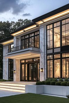 a large white house with lots of windows and steps leading up to the front door