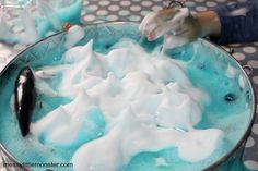 a bowl filled with blue and white liquid on top of a polka dot table cloth