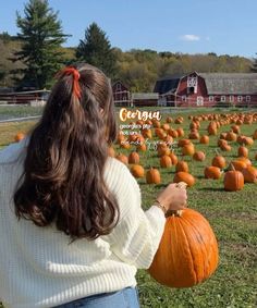 a woman holding a pumpkin in front of a field full of pumpkins with the words georgia written on it