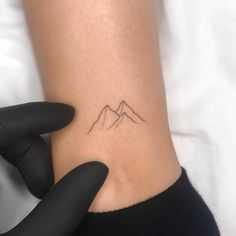 a small mountain tattoo on the wrist