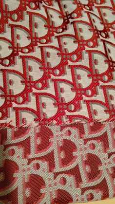 the fabric is red and white with silver letters on it's side, as well as an intricate design