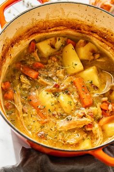 a pot filled with stew and potatoes on top of a table