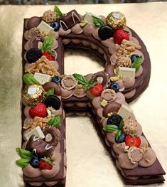 a chocolate letter decorated with fruit and nuts