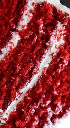 a slice of red velvet cake with white frosting