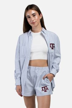 Add a touch of Aggie pride to your look with the Texas A&M Hamptons Button Down! The classic blue and white stripes show off an iconic maroon ATM logo on the left side of the chest, making this shirt the perfect choice for any A&M fan. Show your spirit with a chic and stylish statement piece! - Brand: Hype & Vice - 60% Cotton/40% Polyester - Machine Wash Cold/Tumble Dry Low Cotton Button-up Shirt With Signature Stripes, Casual Button-up Top With Contrast Stripes, Collared Cotton Tops With Signature Stripes, Casual Cotton Shirt With Signature Stripes, Casual Pinstripe Tops For Daywear, Casual White Shirt With Signature Stripes, Cotton Button-up Top With Contrast Stripes, White Button-up Top With Contrast Stripes, Vertical Stripes Cotton Top For Loungewear