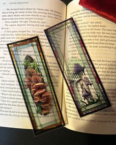 two stained glass bookmarks sitting on top of an open book