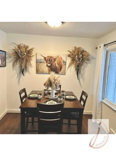 a dining room table with chairs and pictures on the wall