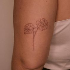 a woman with a tattoo on her arm has a flower in the shape of a leaf