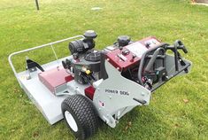 a lawn mower sitting in the grass with its wheels on it's side