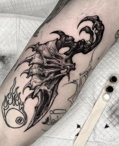 a black and white tattoo on the leg of a man with a dragon head in flames