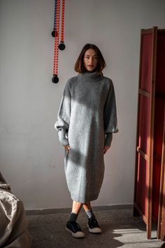 "The winter season is about cozy knitwear and chunky turtlenecks, and this Merino wool dress is about to become your favorite knit. Without a doubt, you do not have to wait for the winter. It is a perfect dress that will easily blend into your fall wardrobe. The minimalist loose silhouette and the hem below the knees will work for everyone with everything, as this is a wardrobe staple that will never go out of style. The flattering raglan shoulders guarantee you will feel at ease, and the wide sleeves gathered at the cuffs will add some sophistication to your hand movements. Pair this wool sweater dress with statement jewelry and modern footwear to look and feel relaxed and confident. WHY PATIS PROJECT? Patis Project is a sustainable slow-fashion brand making timeless staples for the moder Wool Long Dress, Wool Dress Winter, Grey Dress Outfit, Dress With Sweater, Knitted Dress Outfit, Wool Dresses, Cozy Knitwear, Outfit Knit, Grey Clothing