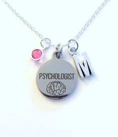 a necklace with the word'm'on it and two charms attached to it