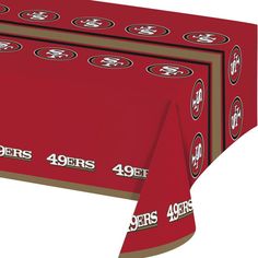 the san francisco giants tablecloth is red with brown trimmings and two football logos on it