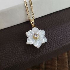 "A beautiful mother of pearl flower charm necklace with cz accent in the center. 14k gold filled cable chain 16-18\" or 18-20\" adjustable chain Flower charm 14x16mm without the bail" White Flower Necklace, Elegant White Flower Necklace For Birthdays, Gold Necklace Flower, Elegant White Flower Necklace For Birth Month, Delicate White Flower Necklace For Anniversary, Elegant White Flower Necklace With Birth Flower Detail, Elegant White Birth Flower Necklace, Dainty White Flower Necklace For Anniversary, White Flower Pendant Necklace For Mother's Day