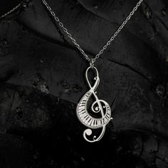 Elevate your ensemble with the timeless elegance of the Sussex Home Treble Clef Necklace. This exquisite piece is meticulously handcrafted from sterling silver and adorned with a lustrous gold plating, making it a stunning choice for any music enthusiast.

- Material: Sterling Silver, Gold Plated
- Color: Gold
- Gender: Female
- Age Group: Adult

Designed with a delicate treble clef pendant, this necklace serves as a symbol of your everlasting love for music. It's the perfect gift for bridesmaid Music-themed Metal Jewelry For Gifts, Silver Music-themed Metal Necklace, Silver Music-themed Metal Jewelry, Music-themed Silver Metal Jewelry, Silver Music-themed Round Jewelry, Silver Sterling Music-themed Necklace, Music-themed Sterling Silver Necklace, Nickel-free Silver Music-themed Necklaces, Music-themed Silver Pendant Necklace